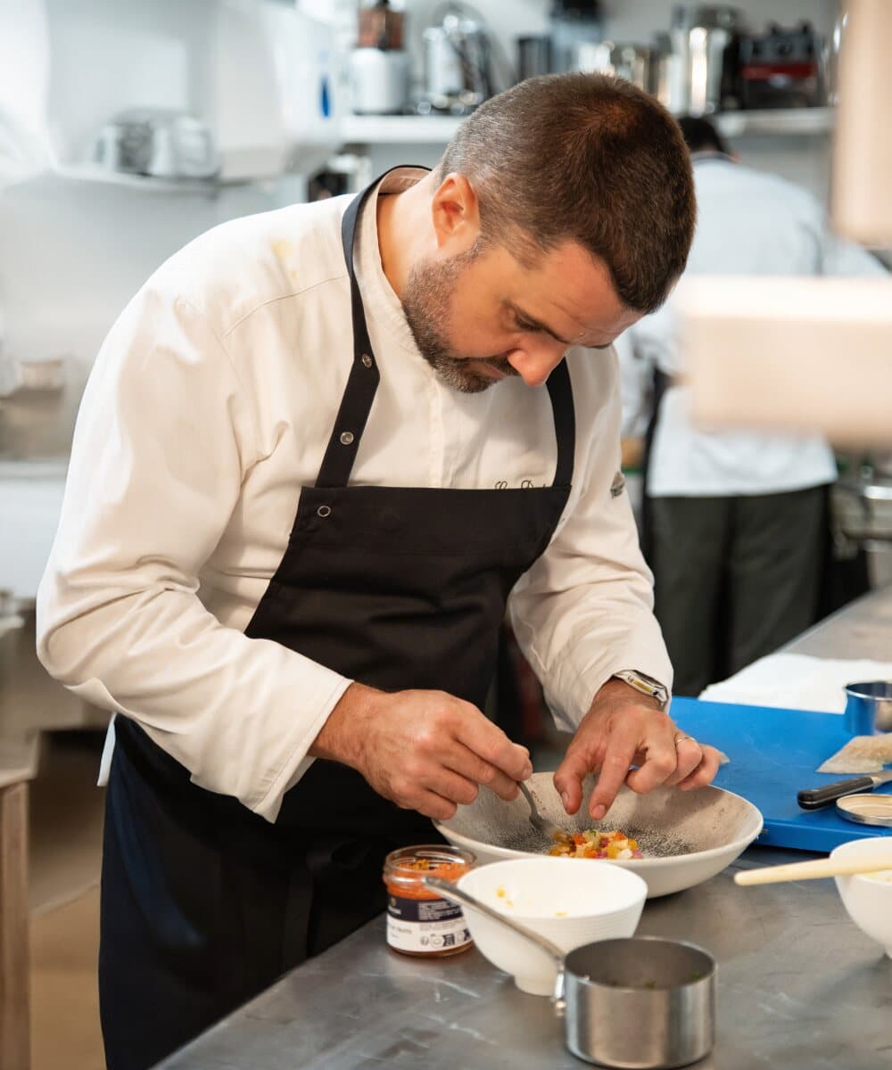 Le chef Loïc Dantec dressant une assiette en cuisine